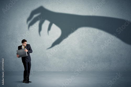 Quadro em tela Business person afraid of a big monster claw shadow concept