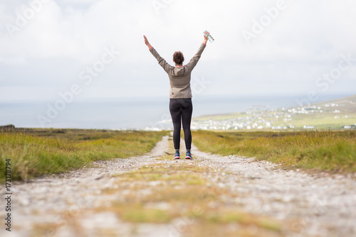 Foto Young woman on a walkway back facing rising arms