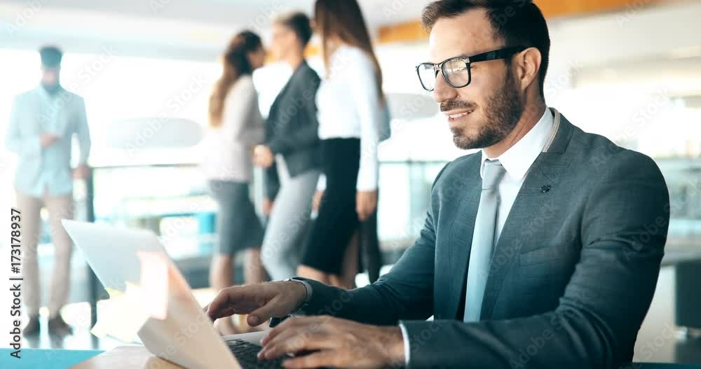 Young handsome architect working on laptop in office