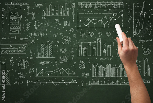 A business person drawing data on chalkboard