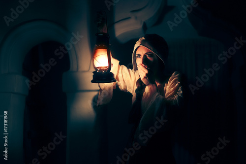 Scared Medieval Woman with Vintage Lantern Outside at Night