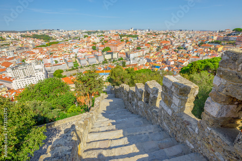 A spectacular aerial view of Lisbon cityscape and ancient fortress wall of Sao Jorge Castle a Moorish castle on highest hill in Alfama District, historic center of Lisbon. Portugal, Europe,