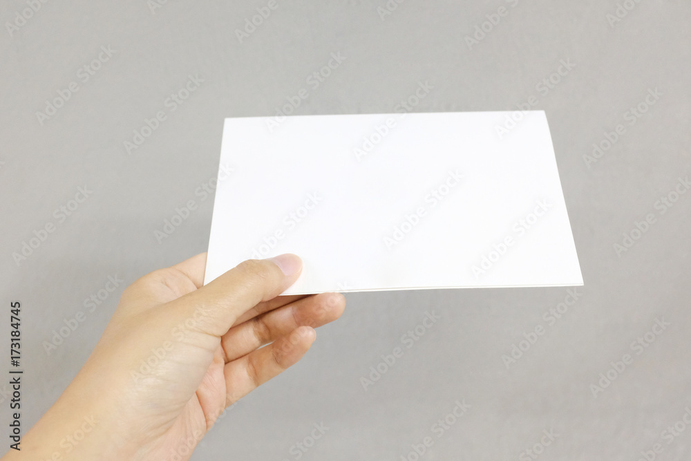 A hand holding a paper card