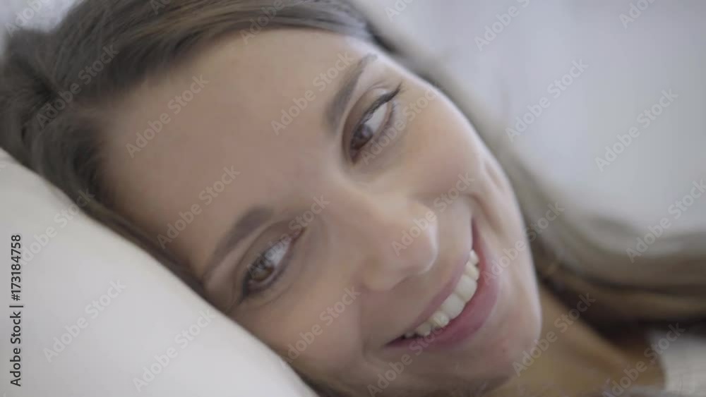 4k video closeup face of smiling young woman in bed looking at her husband in the morning 4k video closeup face of smiling young woman in bed looking at her husband in the morning