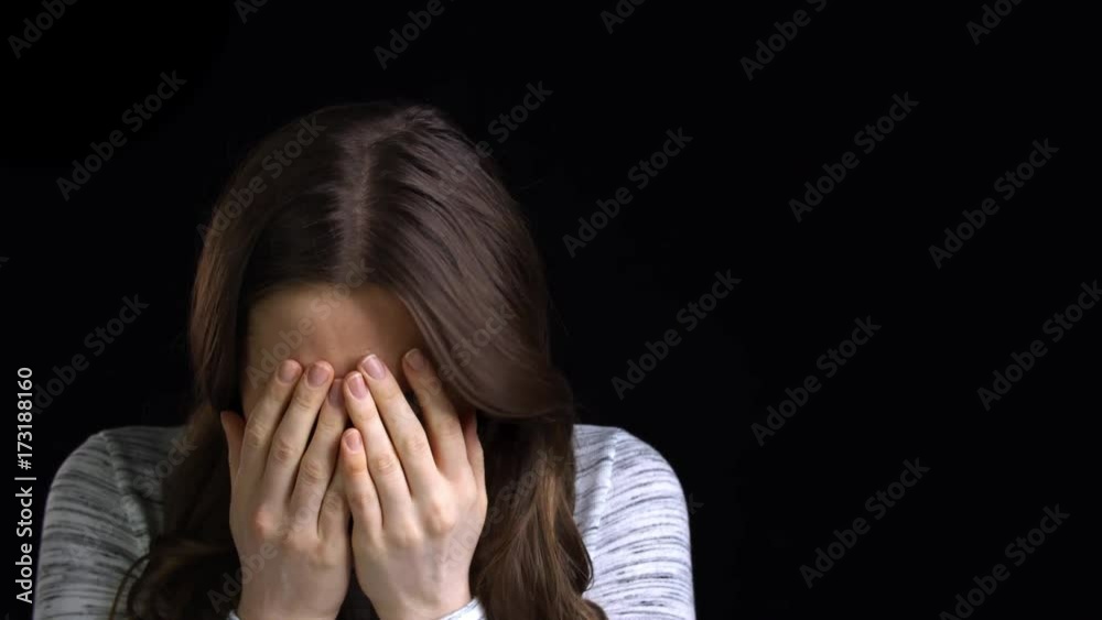 Studio Shot Of Scared Young Woman Flinching From Abuse Studio Shot Of Scared Young Woman Flinching From Abuse