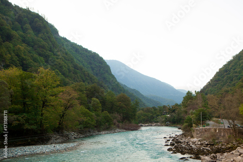beautiful high mountains with a green summer landscape with a stormy river