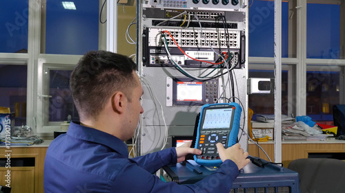 Wave on oscilloscope. Man enters the values in the oscilloscope