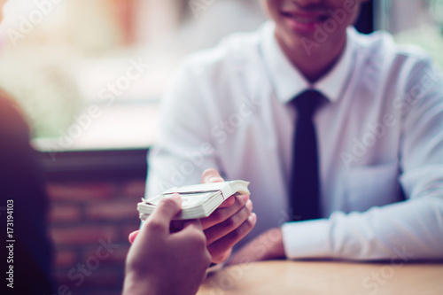 Hand giving money - United States Dollars (or USD)