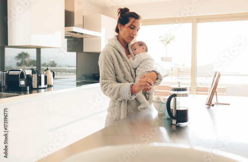 Woman with her son in kitchen making baby food