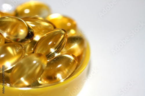 Transparent yellow capsules of fat-soluble vitamins. Vitamin A, E