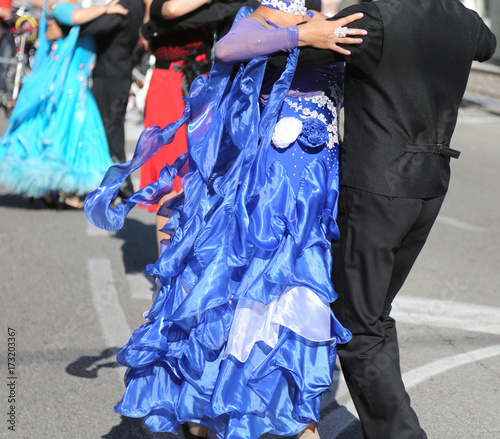 woman with long blue dress dancing with a man on the street