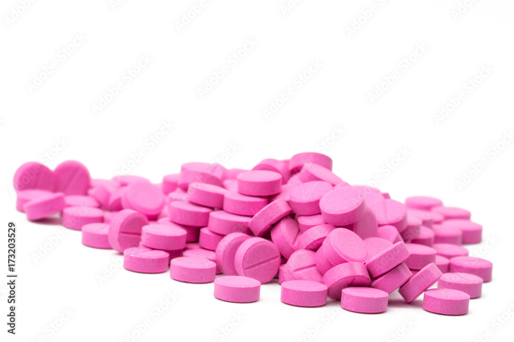 Pile of pink tablets pills isolated on white background with clipping path. Copy space