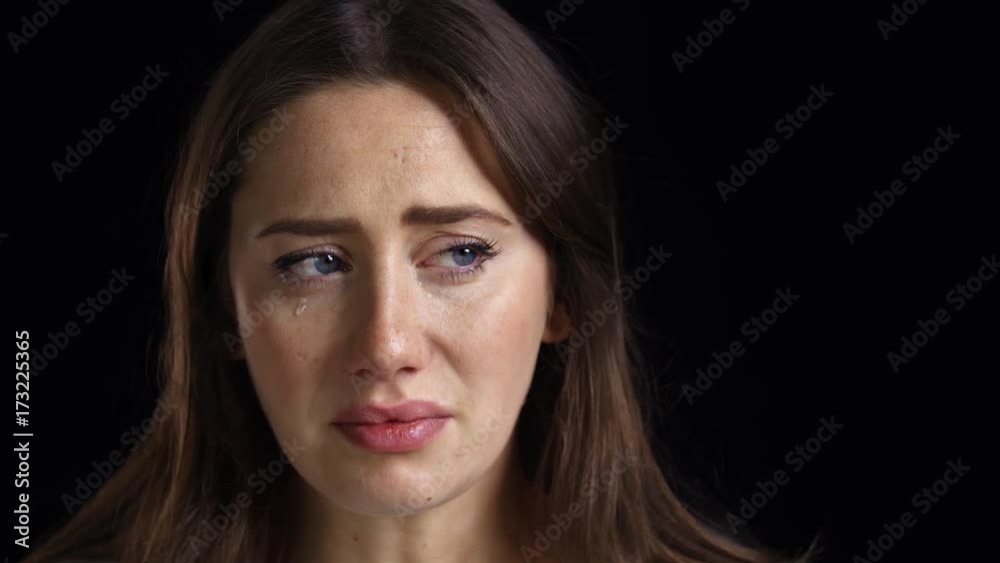 Studio Shot Of Unhappy Young Woman Crying Into Camera Studio Shot Of Unhappy Young Woman Crying Into Camera