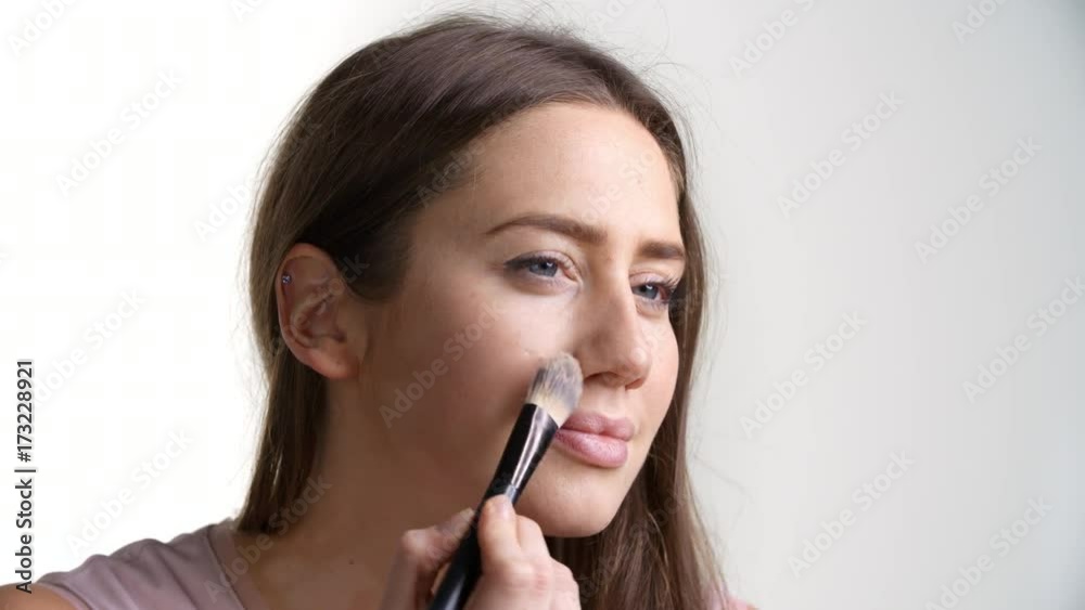 Studio Shot Of Attractive Woman Putting On Face Powder Studio Shot Of Attractive Woman Putting On Face Powder