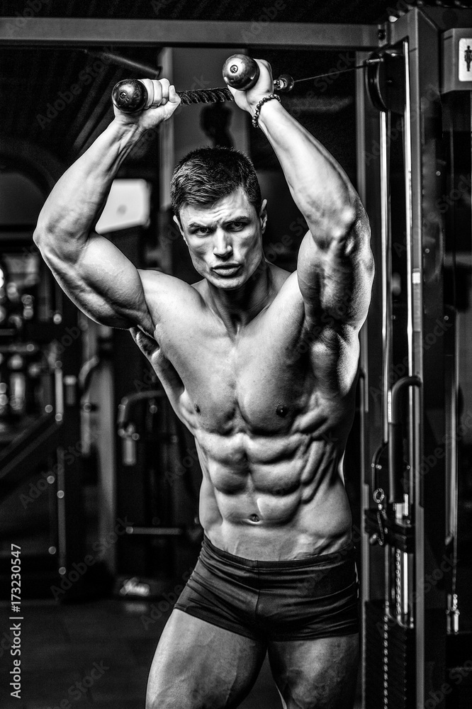 Handsome model young man training abs in gym