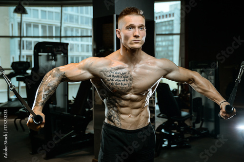 Brutal Caucasian bodybuilder training chest in gym