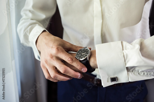 businessman clock clothes, businessman checking time on his wristwatch. men's hand with a watch, watch on a man's hand, the fees of the groom, preparation for work, putting the clock on the hand