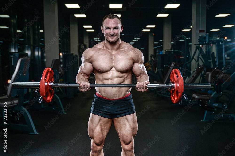 Handsome model young man training arms in gym Handsome model young man training arms in gym