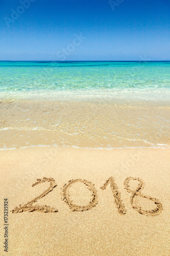 2018 written on sandy beach