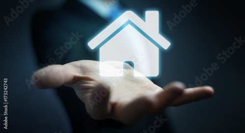 Businessman holding 3D rendering icon house in his hand