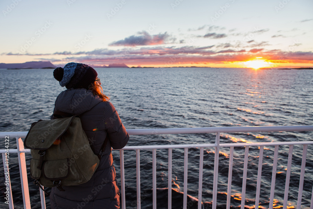 Woman traveler with backpack on the deck of a ferry in the Atlantic Ocean Woman traveler with backpack on the deck of a ferry in the Atlantic Ocean