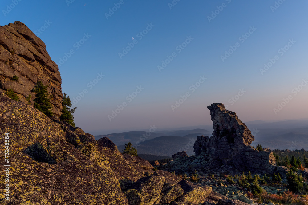Huge rocks on top of a mountain ridge in the background of a sunset in autumn