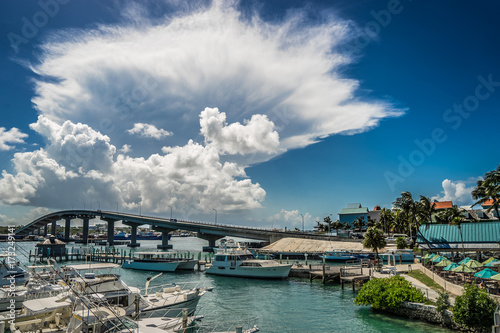 Beautiful curved bridge with yachts in the foreground and a thundercloud in the background. Nassau, Bahamas