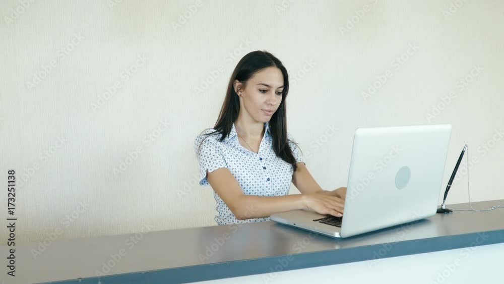 Portrait of a young attractive woman working at the reception or the hotel company. People stock footage slider shot. Portrait of a young attractive woman working at the reception or the hotel company. People stock footage slider shot.