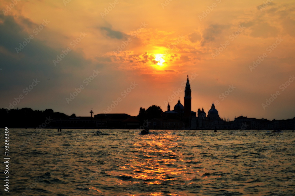 sunset on the sea against the backdrop of buildings in Venice