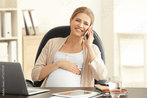 Young pregnant woman working in home office