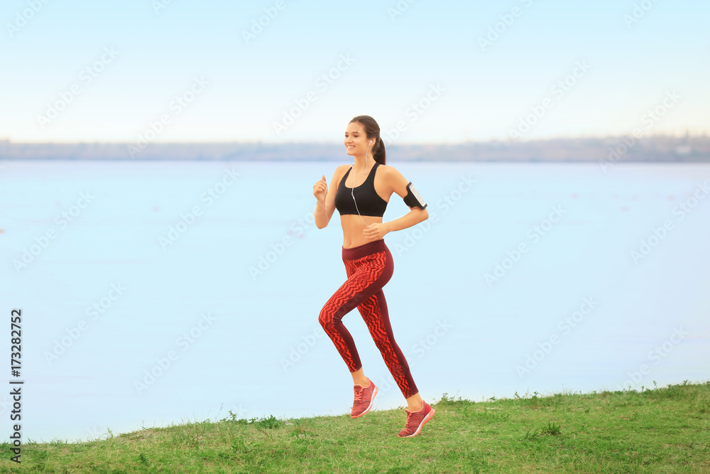 Young sporty woman running on river shore Young sporty woman running on river shore