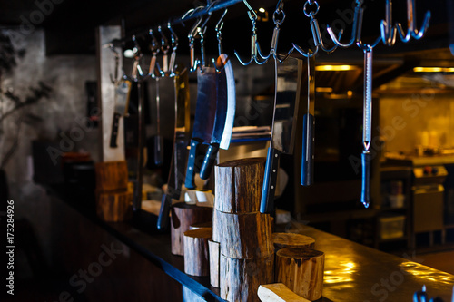 Many large knife hanging wooden storage in the kitchen of restaurant
