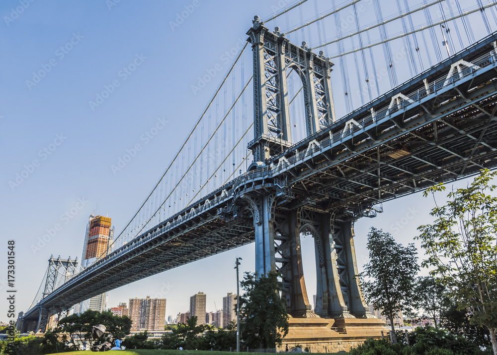 A view of the Manhattan Bridge from Brooklyn early in the morning with blue sky and sun shine - Brooklyn, New York, NY, United States of America, USA