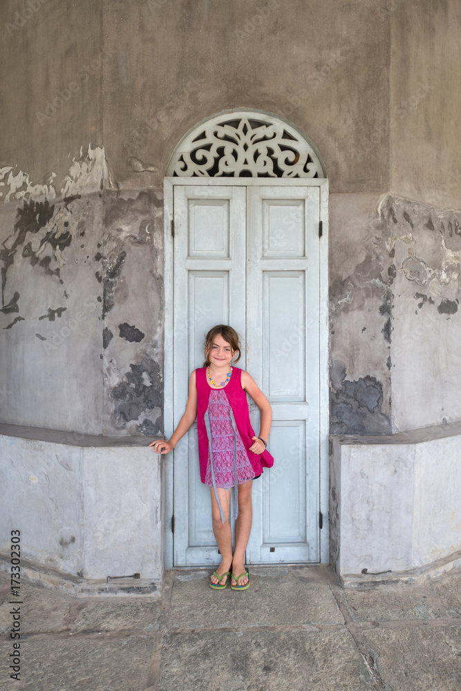 Young girl in front of a old building