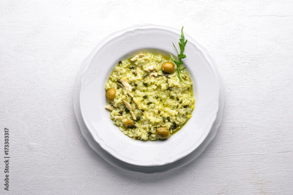 Risotto with spinach, cheese and olives. On a wooden background. Top view. Free space. Risotto with spinach, cheese and olives. On a wooden background. Top view. Free space.