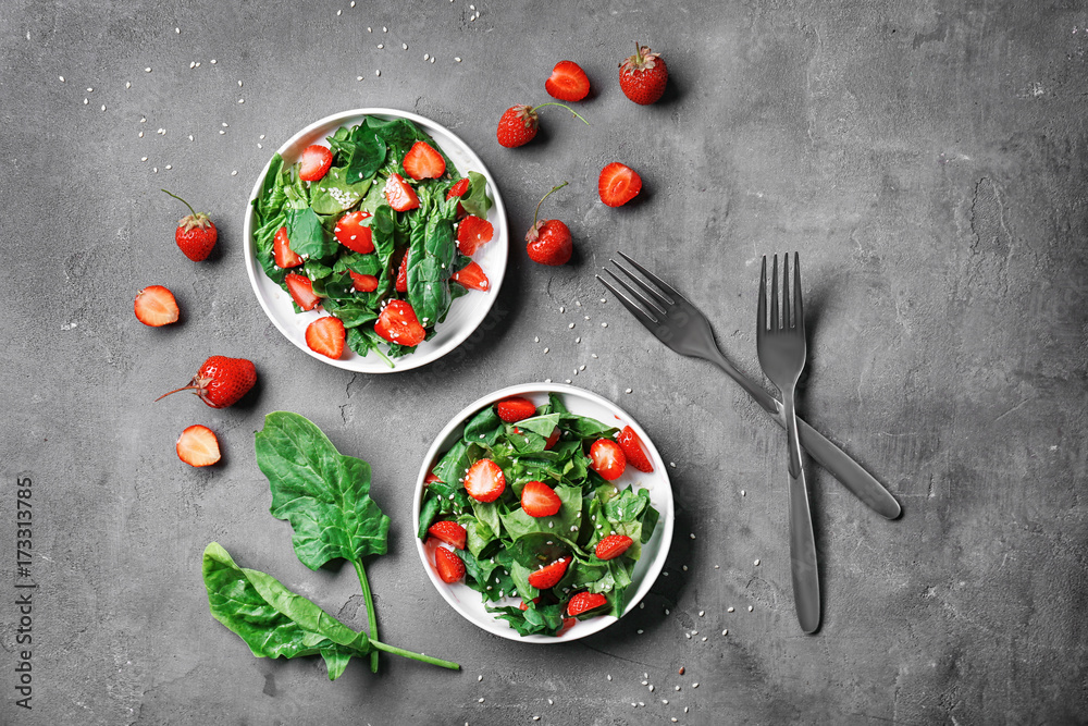 Plates with strawberry spinach salad on table Plates with strawberry spinach salad on table