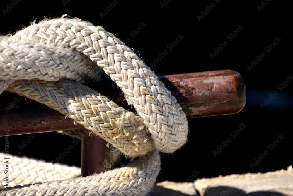 Rope knotted at a pier. With bollard.