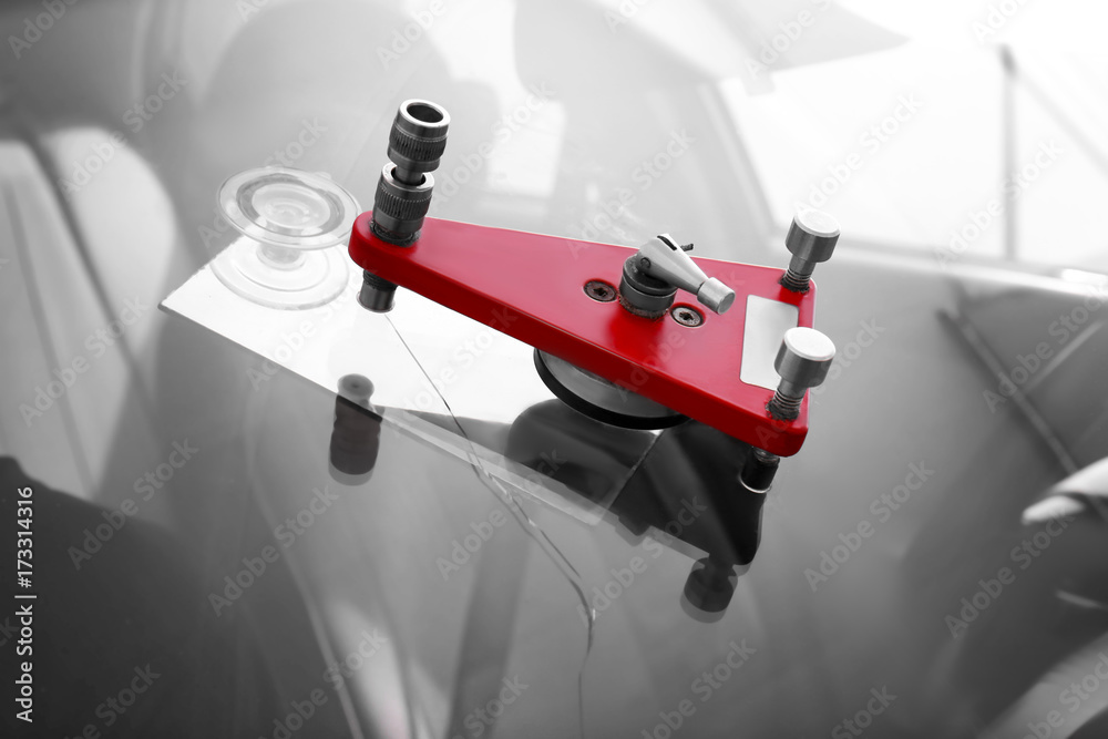 Fixing crack on car windshield in repair shop Fixing crack on car windshield in repair shop