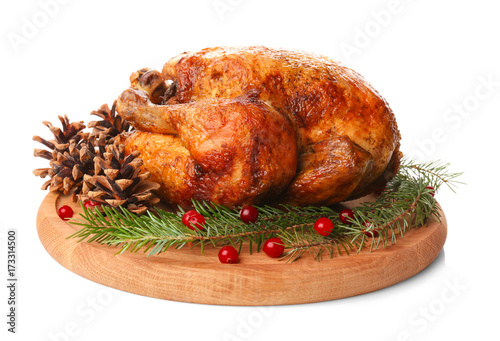 Wooden board with roasted turkey, cones and fir tree branches on white background