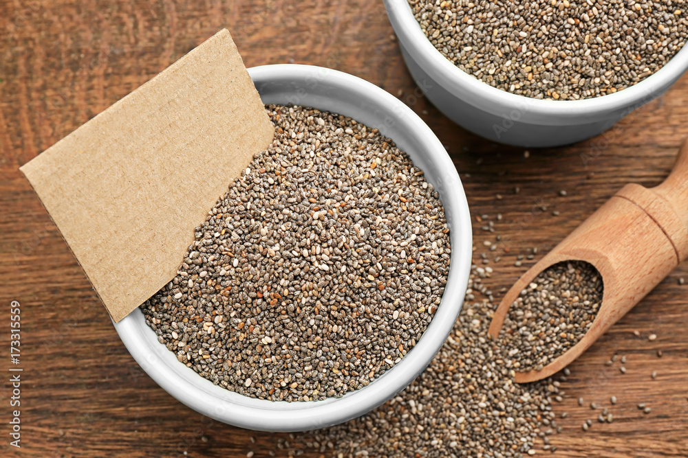 Composition with chia seeds in kitchenware on table Composition with chia seeds in kitchenware on table