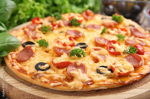 Tasty pizza with sausage on wooden board, close up