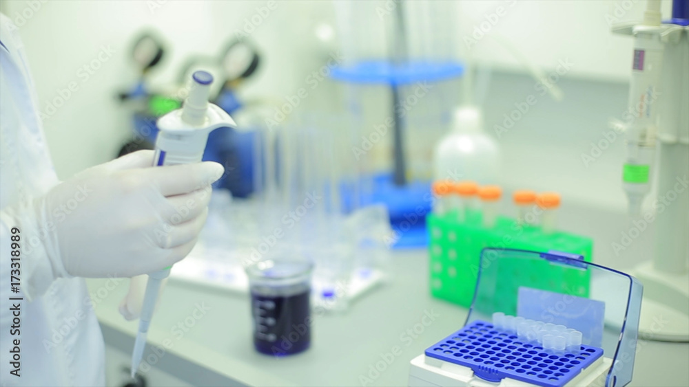 Fototapeta premium Test tubes closeup. Medical equipment. Close-up footage of a scientist using a micro pipette in a laboratory. Laboratory technician injecting liquid into a microtiter plate. Test tubes. Small depth of