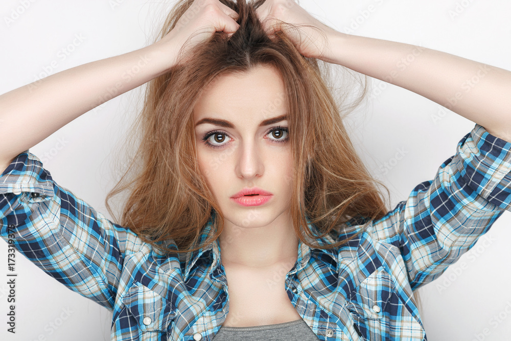 Beauty portrait of young adorable fresh looking blonde woman in blue plaid shirt. Emotion and facial expression concept. Beauty portrait of young adorable fresh looking blonde woman in blue plaid shirt. Emotion and facial expression concept.