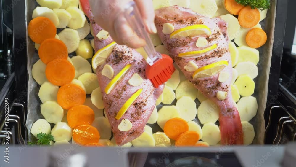 Vidéo Stock Woman cooking whole roasted fish rockfish baked in the oven