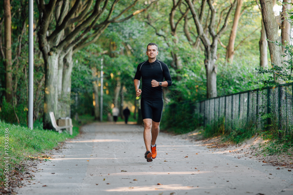 Athlete young man running in park.