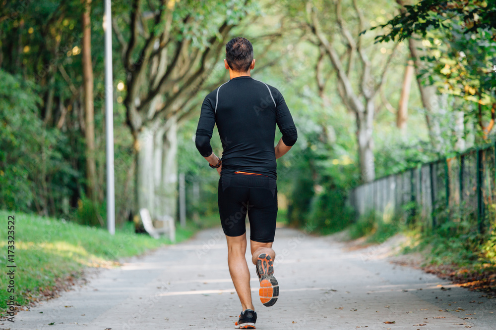 back view of athlete young man running in park. back view of athlete young man running in park.