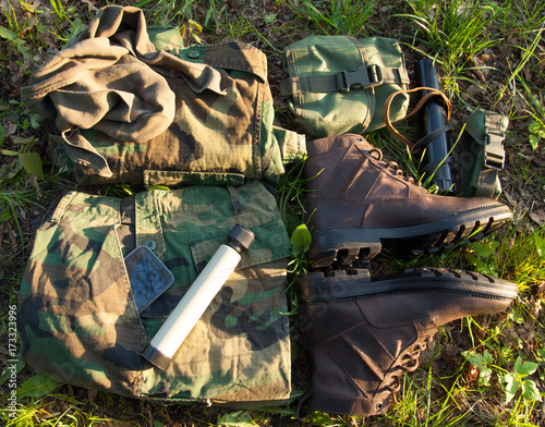 Obraz na plátně Military camouflage clothes and soldier belongings on the grass