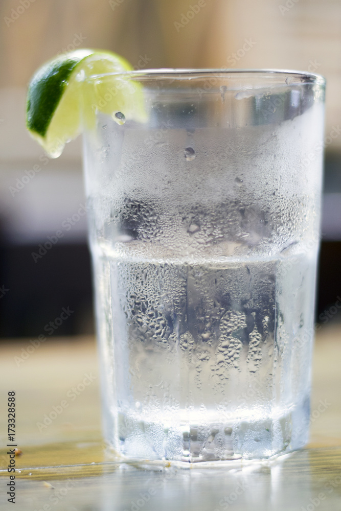 Glass of water with condensation and lime wedge Glass of water with condensation and lime wedge