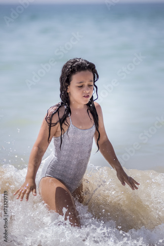 Niña morena bañándose en el mar y jugando con las olas. foto de Stock |  Adobe Stock