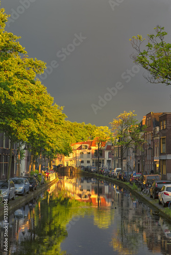 Travel Concepts and Ideas. Traditional Dutch Channels Located in Old City Delft. Picture Taken During amazing Picturesque Sunlight Straight After the Rain with Grey Clouds.